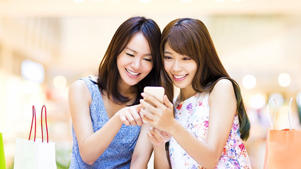 在看手机的两个女孩，图片用于信用卡优惠